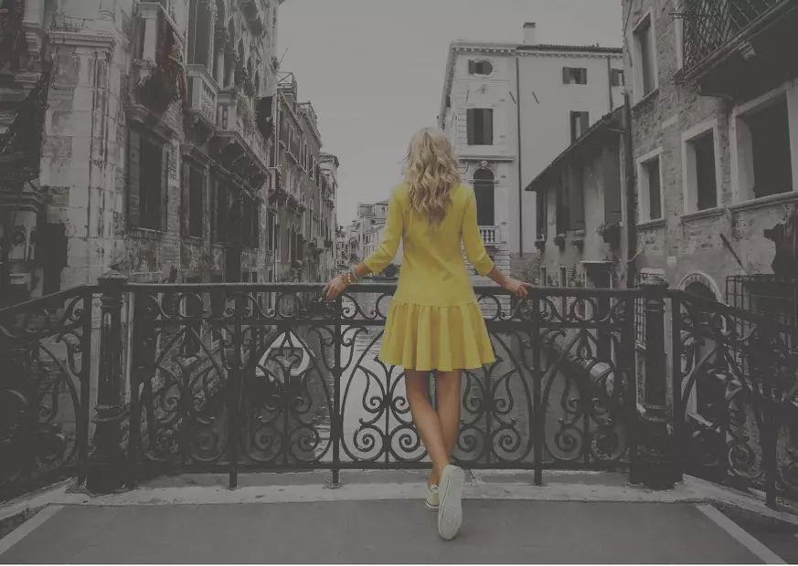 Chica de esoaldas con vestido amarillo en Venecia.